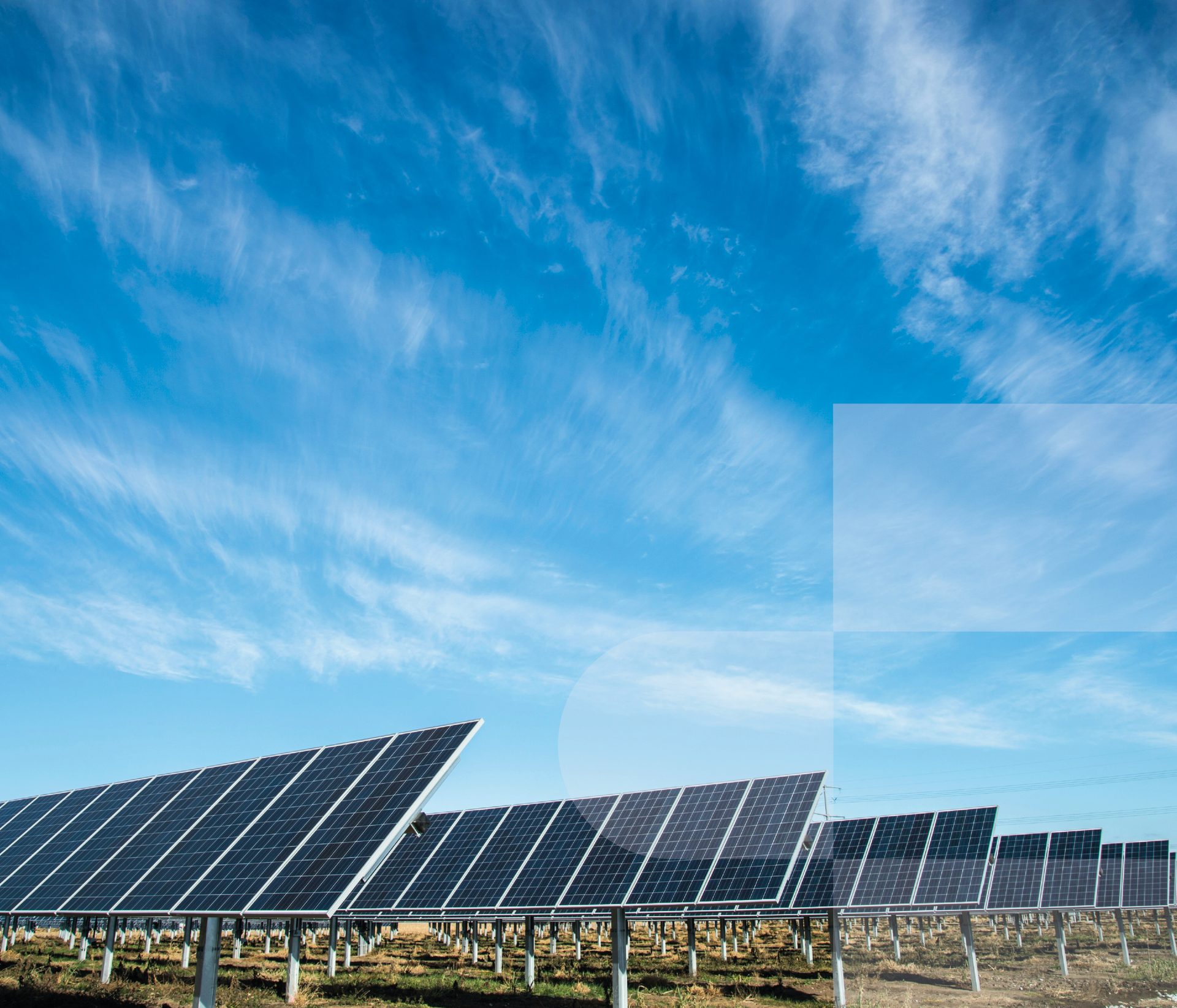 Rows of solar panels under a blue sky with clouds.